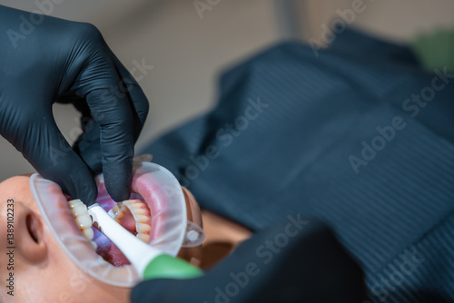 Dentist performing teeth whitening procedure on patient in dental clinic