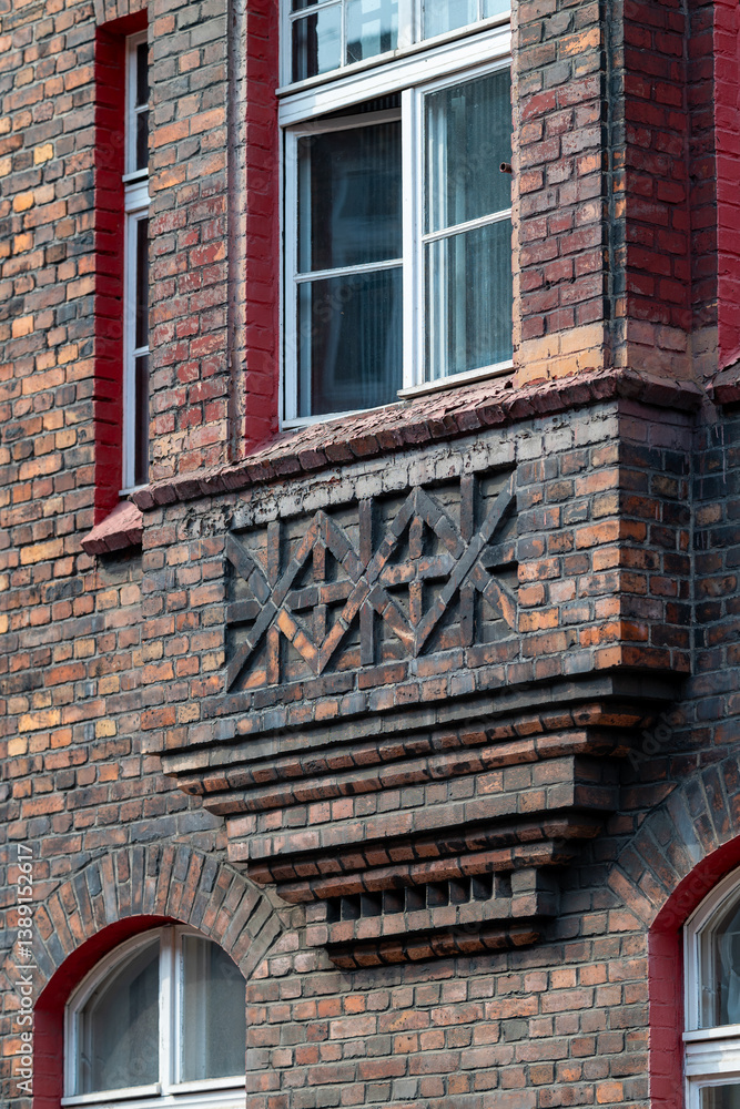 Brick facade of a tenement house in a workers' housing estate. Beautiful window detail. White window frames. Bay window. Historic housing estate Katowice Nikiszowiec. Poland
