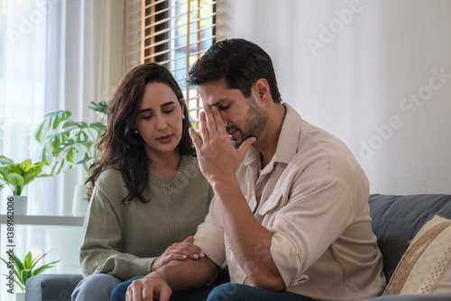Supportive couple in emotional moment at home as woman struggles with sadness and stress, expressing