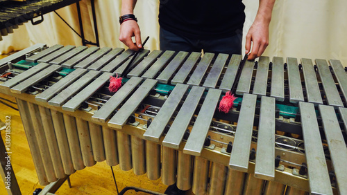 A young guy playing the vibraphone at a music school.