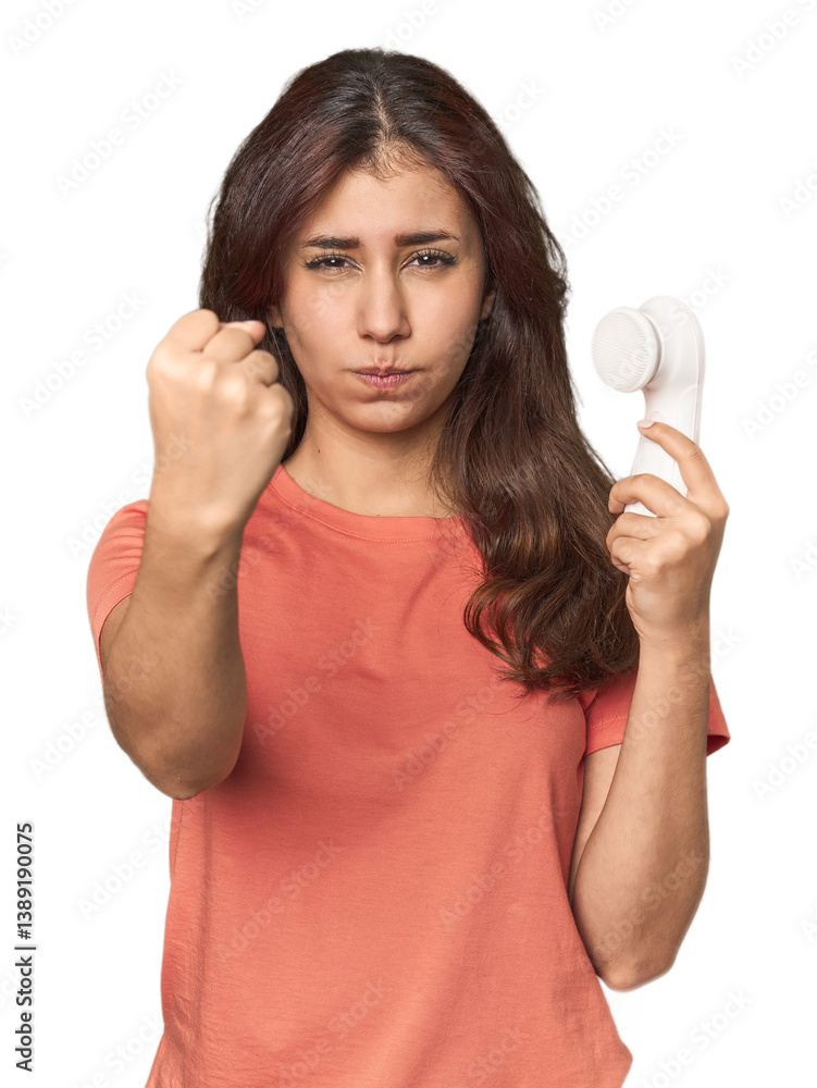 Middle Eastern woman with facial cleanser showing fist to camera, aggressive facial expression.