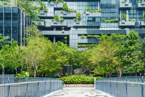 Modern eco-friendly architecture with vertical garden and greenery surrounding office glass building in urban environment in Bangkok city, Thailand. Green architecture and sustainable design