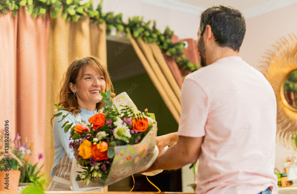 Florist giving bouquet of flowers to customer in flower shop Florist giving bouquet of flowers to customer in flower shop