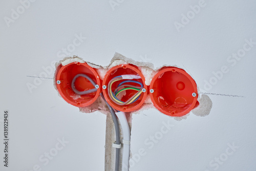 Obraz na płótnie Electrical wiring installation during renovation. Three plastic outlet boxes with exposed electrical wires embedded in wall. Unfinished wall with visible electrical wiring and socket holders w salonie