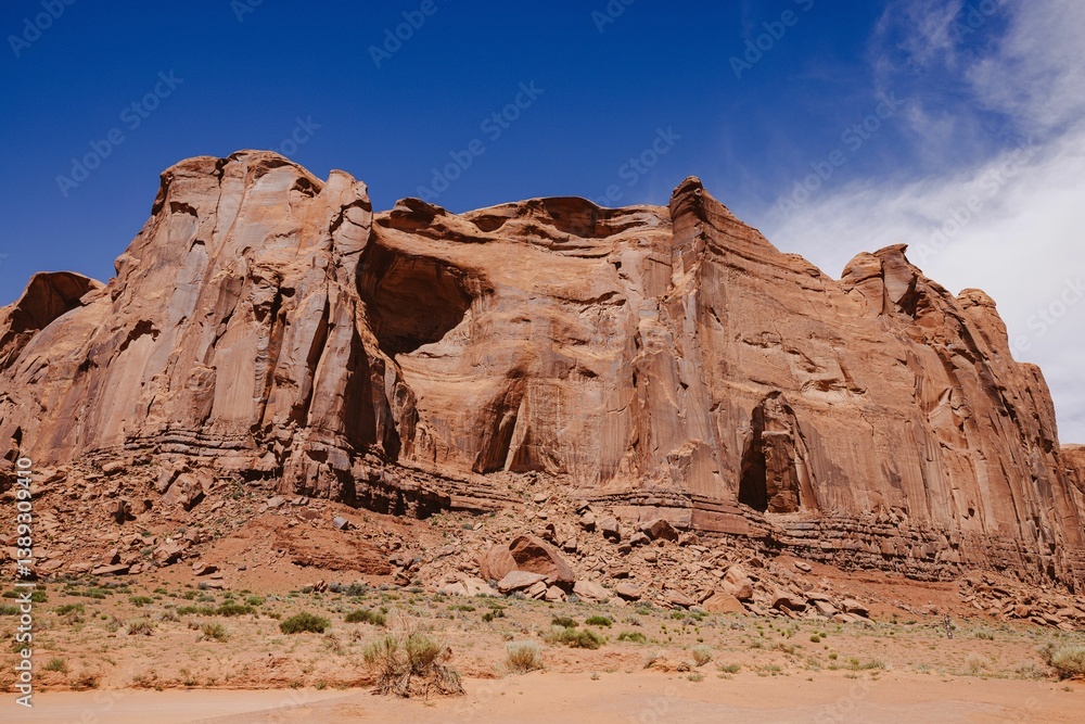 Fototapeta premium Monument Valley rock formations under a blue sky.