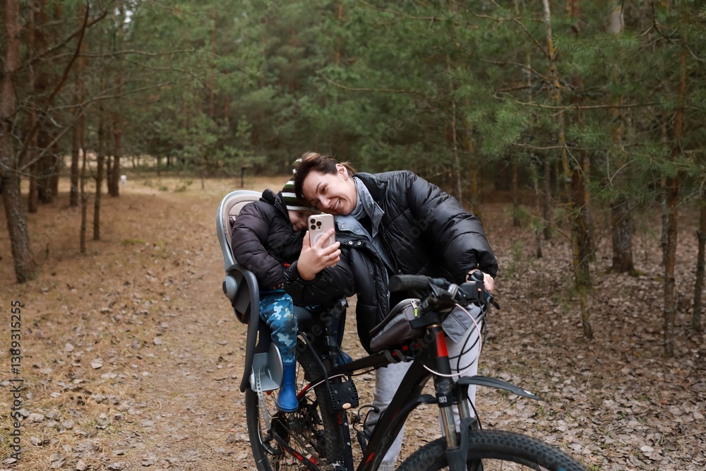 Family enjoys a joyful bike ride through the woods on a sunny afternoon while capturing a selfie together