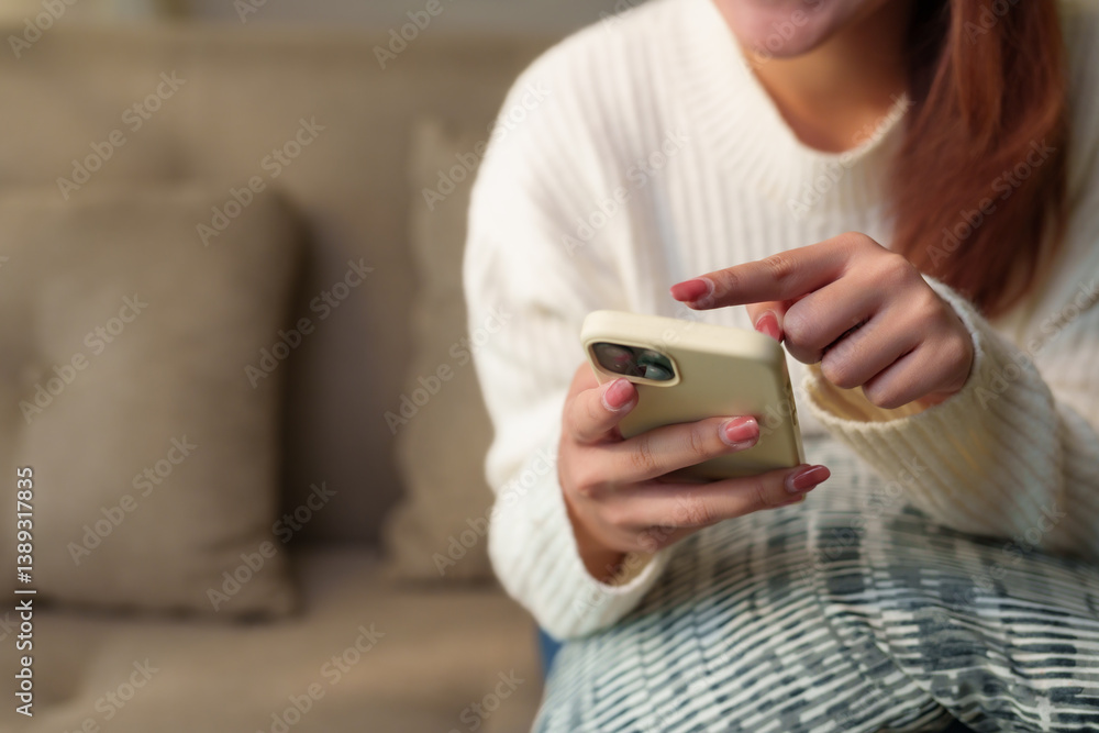 Woman relaxing on a cozy sofa at home, browsing the internet and engaging with social media on her smartphone, enjoying leisure time Woman relaxing on a cozy sofa at home, browsing the internet and engaging with social media on her smartphone, enjoying leisure time