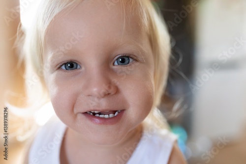 Obraz na płótnie Smiling toddler with bright blue eyes enjoying playtime indoors during daytime w salonie