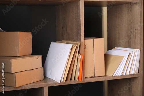 Obraz na plátně Different paper envelopes and parcels on wooden shelves in post office