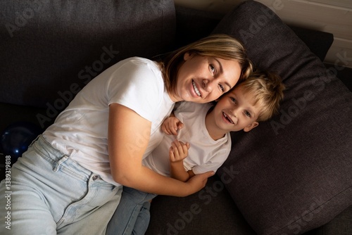 Obraz na płótnie Smiling mother and son share a cozy moment together on the couch in a comfortable living room setting w salonie