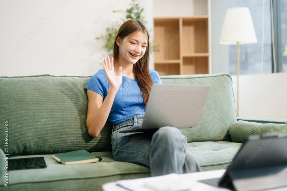 Young asian woman using smartphone and tablet while seated on couch at home Young asian woman using smartphone and tablet while seated on couch at home