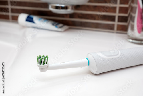 Close-up a modern electric toothbrush on the bathroom sink.