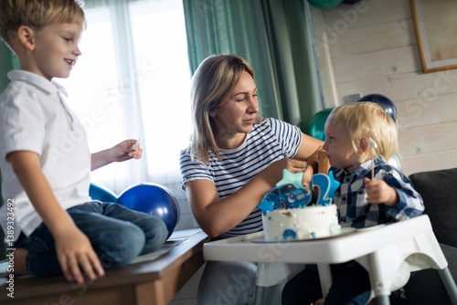 Family celebration with children enjoying cake and balloons in a cozy indoor setting