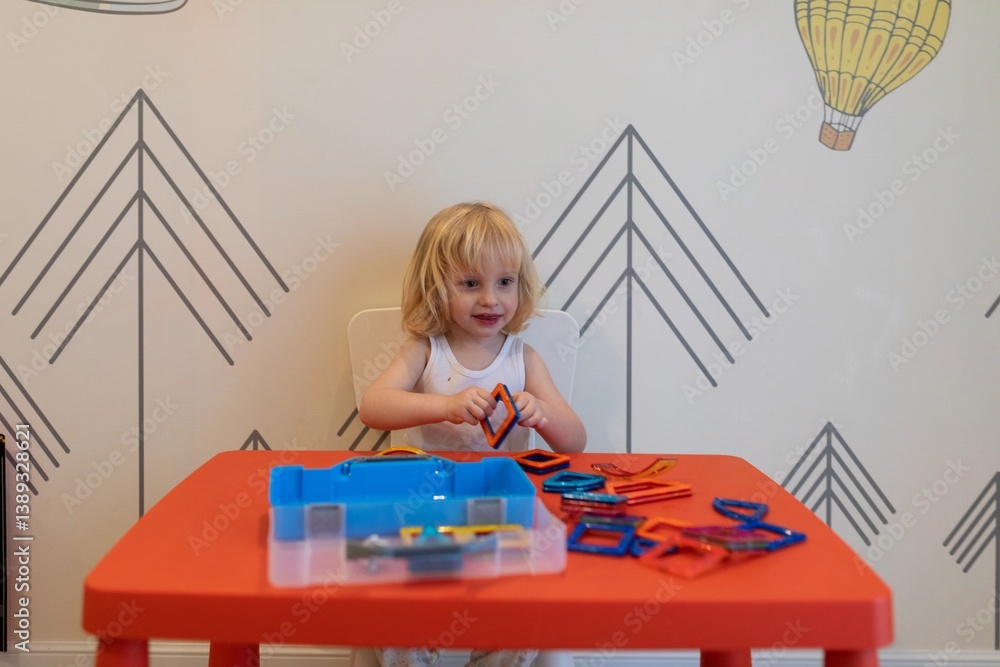 Young child engages in creative play with colorful building shapes at home in a cheerful room setting