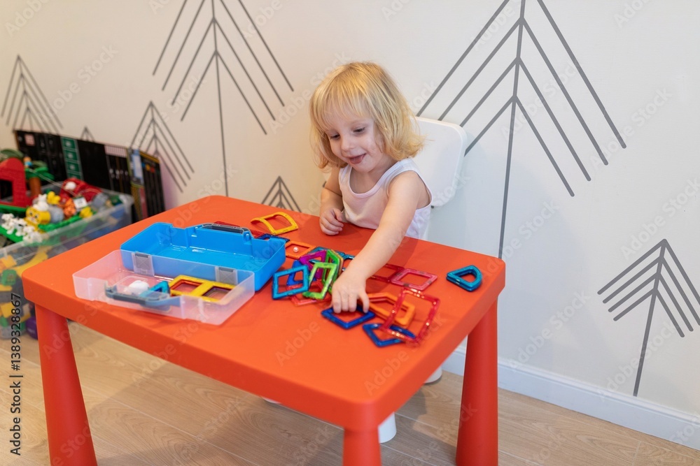 Child engages in creative play with colorful building shapes at a bright indoor activity space