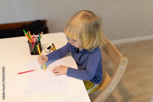 Obraz na płótnie Child engaged in creative drawing activity at a bright indoor workspace during daytime w salonie
