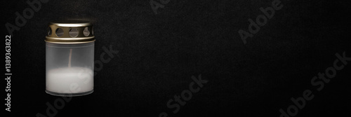 Schilderij op canvas Plastic container with unlit white candle on dark black table background