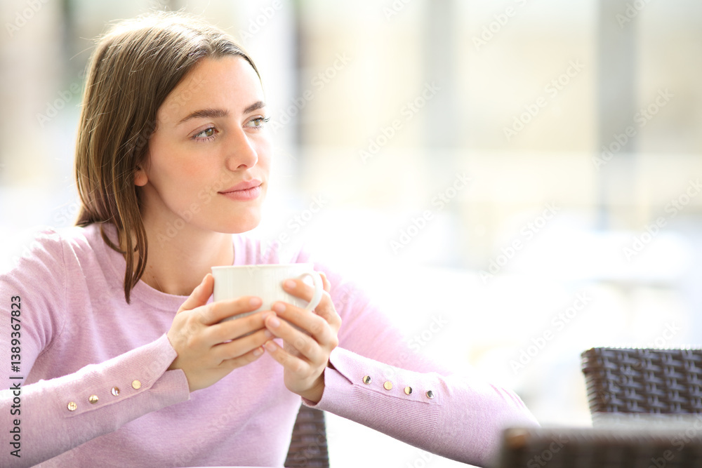 Relaxed woman drinking coffee in a restaurant looking at side Relaxed woman drinking coffee in a restaurant looking at side