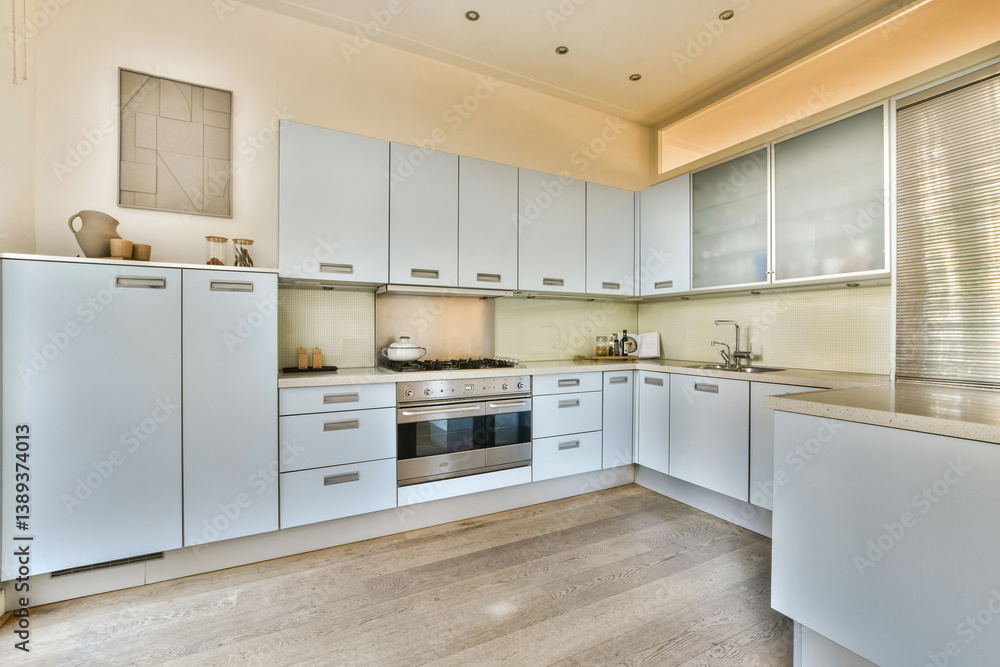 Fototapeta premium Sleek and stylish kitchen featuring light cabinetry, efficient layout, and modern appliances that enhance the cooking space's functionality and aesthetics.