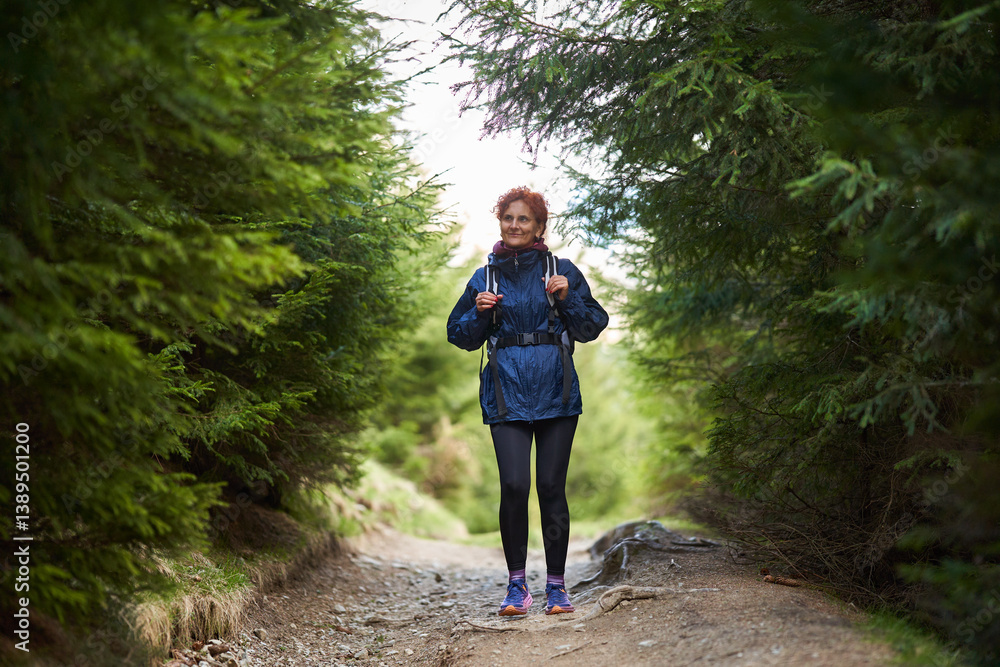 Woman hiking on forest trail.........