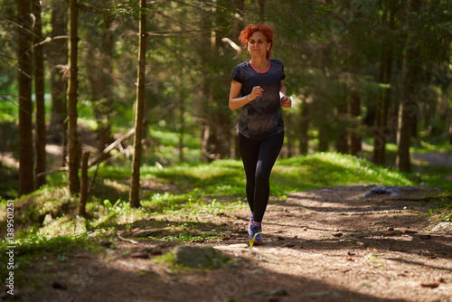 Woman jogging in forest trail.........
