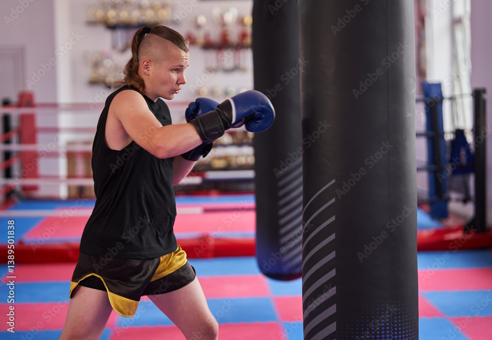 Boxer hitting heavy bag in gym training session.........