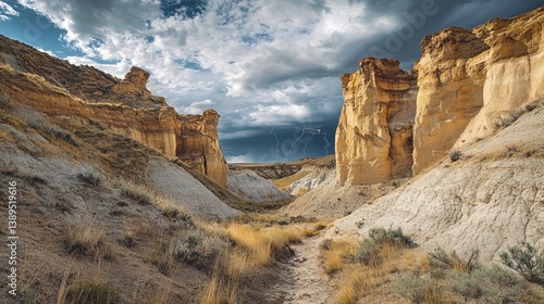 Obraz na płótnie A stunning view of dramatic cliffs and sandy paths under a cloudy sky. Nature unfolds its beauty in vast landscapes. Explore the wonders of this valley. Generative AI w salonie