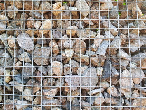 Steel mesh on gabion fence wall. Gray stone in gabion.	