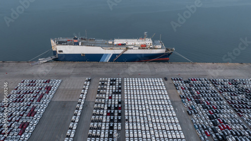 Obraz na płótnie Top view new cars at industrial port import export, New cars park in row stock industrial port parking lot shipping transportation retailer dealership, New cars automotive industry logistics business. w salonie