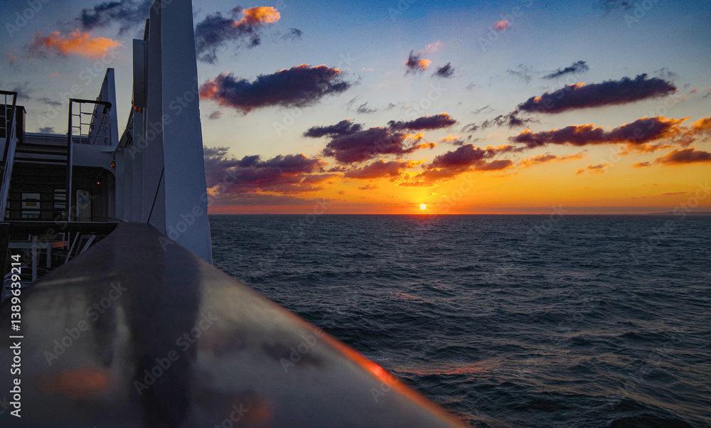 Beautiful breathtaking sunset blue hour twilight panorama at sea with dramatic sky seen from outdoor deck of classic cruiseship cruise ship liner sailing on ocean