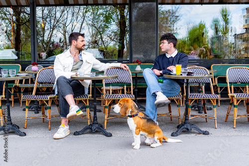 Photography Two friends enjoying a conversation at a Parisian outdoor cafe with their beagle