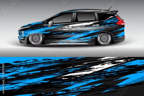 Sleek modified car with blue and black graphic design parked on a smooth surface under soft lighting