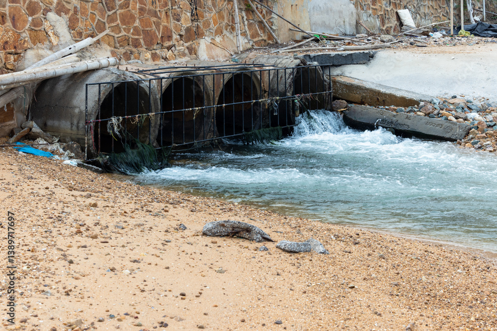 Wastewater discharge sewer flows into the sea from refinery factory, Wastewater pollution of sea ecosystem, Industrial wastewater discharges liquid industrial waste into the sea on beach.