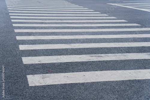 Obraz na płótnie Empty crosswalk on a city street with striped white lines, indicating pedestrian crossing area. Concept of urban infrastructure, pedestrian safety, and road design. High quality photo w salonie