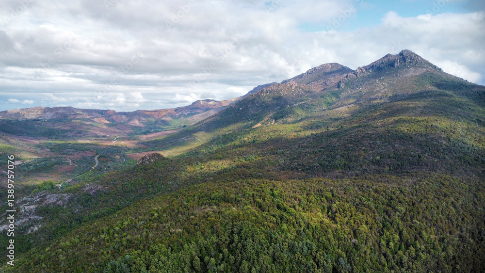 Fototapeta premium Dark lakes between the mountains of Tasmania on a cloudy day, seen from above
