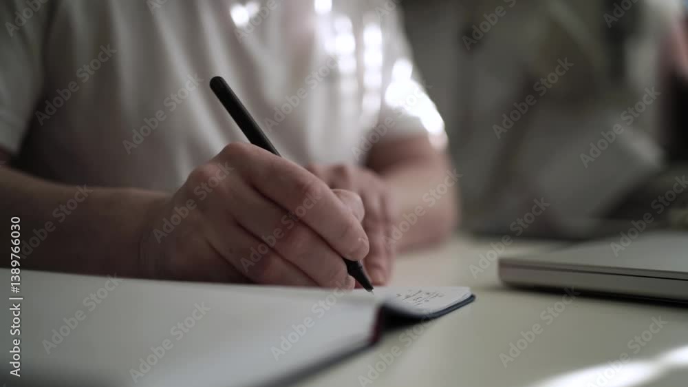 Man’s Hand Holding a Pen While Writing on a Notebook. Journaling his thoughts into notebook, because he has some sort of depression Man’s Hand Holding a Pen While Writing on a Notebook. Journaling his thoughts into notebook, because he has some sort of depression