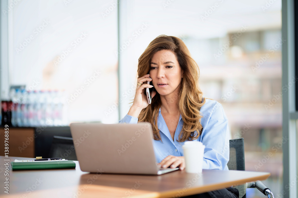 Shot of a blond businesswoman working on a laptop in an office Shot of a blond businesswoman working on a laptop in an office