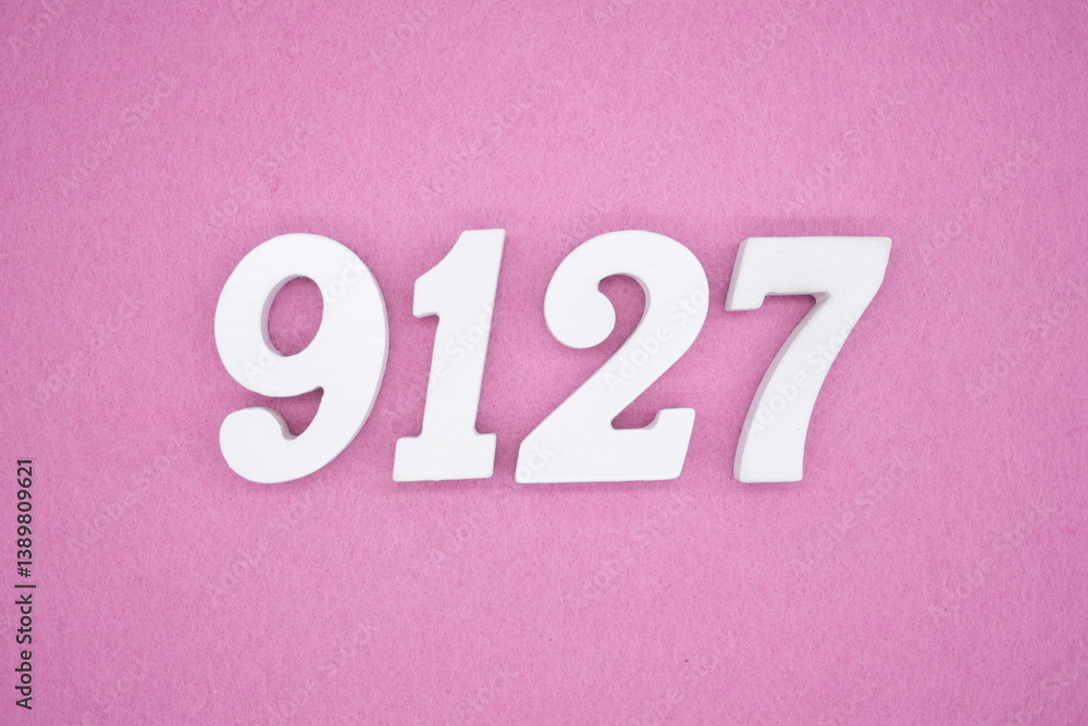 The numbers are made of white painted wood and placed on a pink paper background. The numbers are made of white painted wood and placed on a pink paper background.