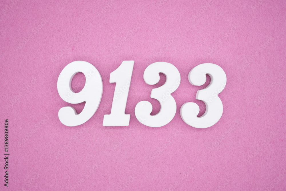 The numbers are made of white painted wood and placed on a pink paper background. The numbers are made of white painted wood and placed on a pink paper background.