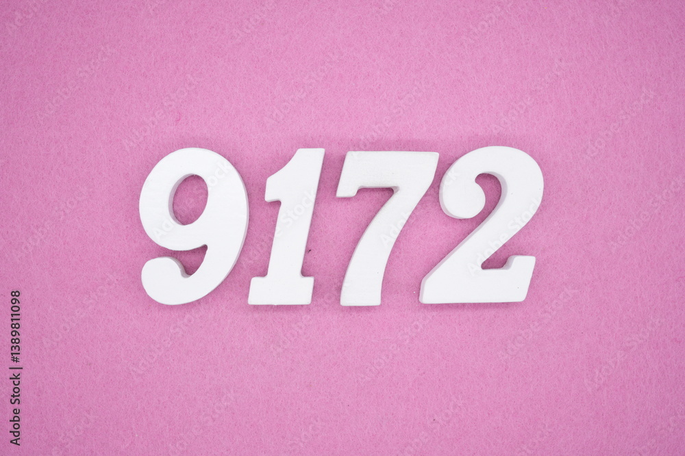 The numbers are made of white painted wood and placed on a pink paper background. The numbers are made of white painted wood and placed on a pink paper background.