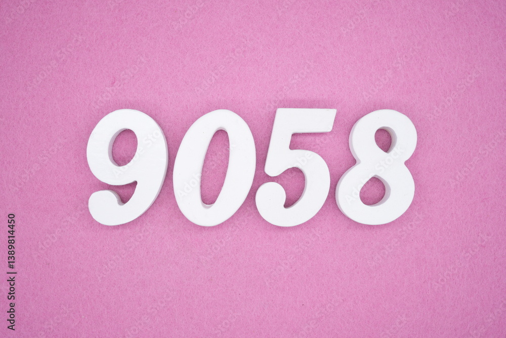 The numbers are made of white painted wood and placed on a pink paper background. The numbers are made of white painted wood and placed on a pink paper background.