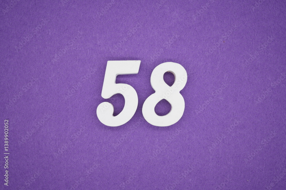The numbers are made of white painted wood placed on a purple paper background. The numbers are made of white painted wood placed on a purple paper background.