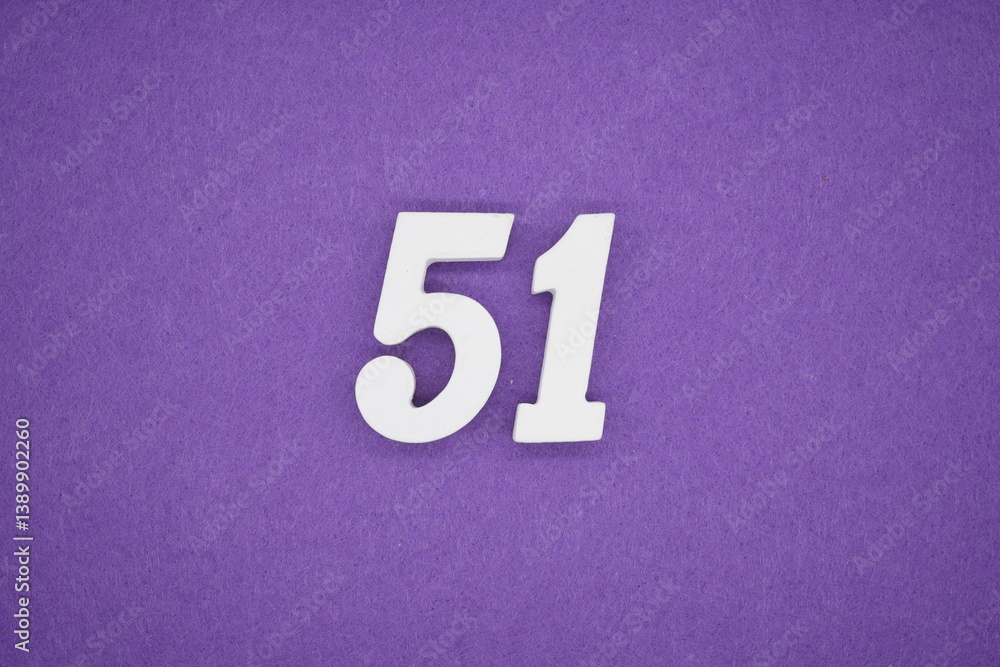 The numbers are made of white painted wood placed on a purple paper background. The numbers are made of white painted wood placed on a purple paper background.