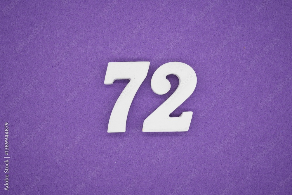 The numbers are made of white painted wood placed on a purple paper background. The numbers are made of white painted wood placed on a purple paper background.