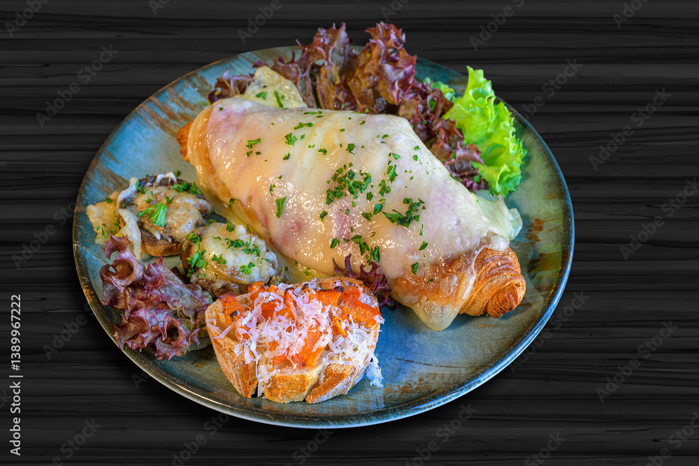 croisant topped with ham and cheese, toasted white bread with tomato and parmesan cheese