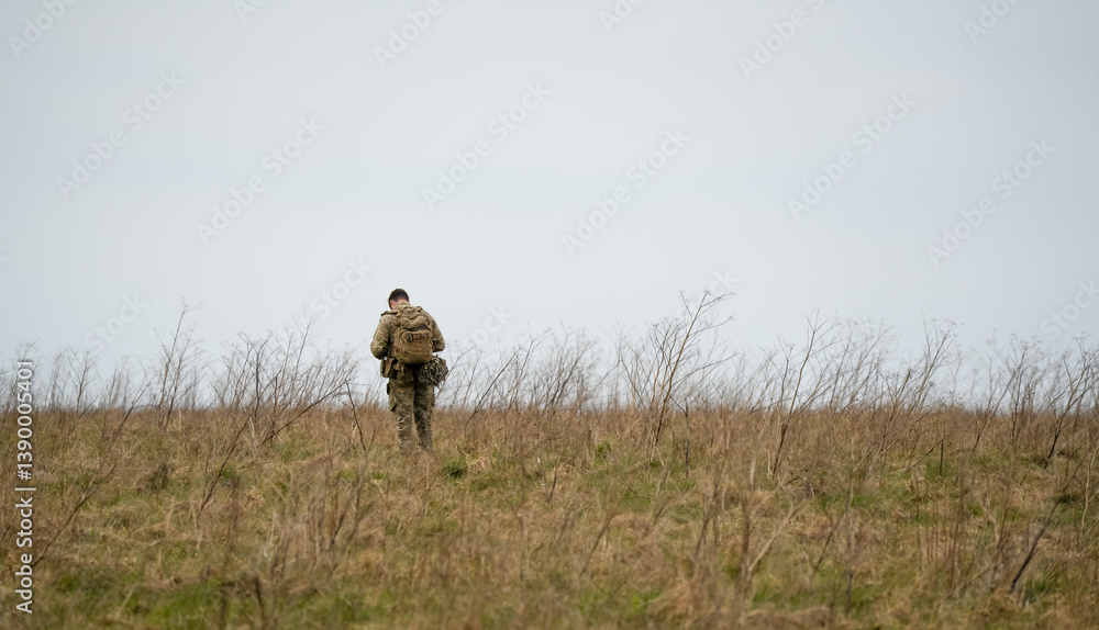 British army soldier tabbing with 25Kg bergen in countryside