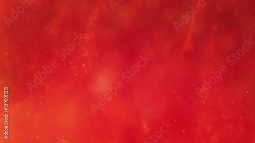 liquid with dissolved particles of red orange candurin and bubbles slowly moves and shines. abstract bright background