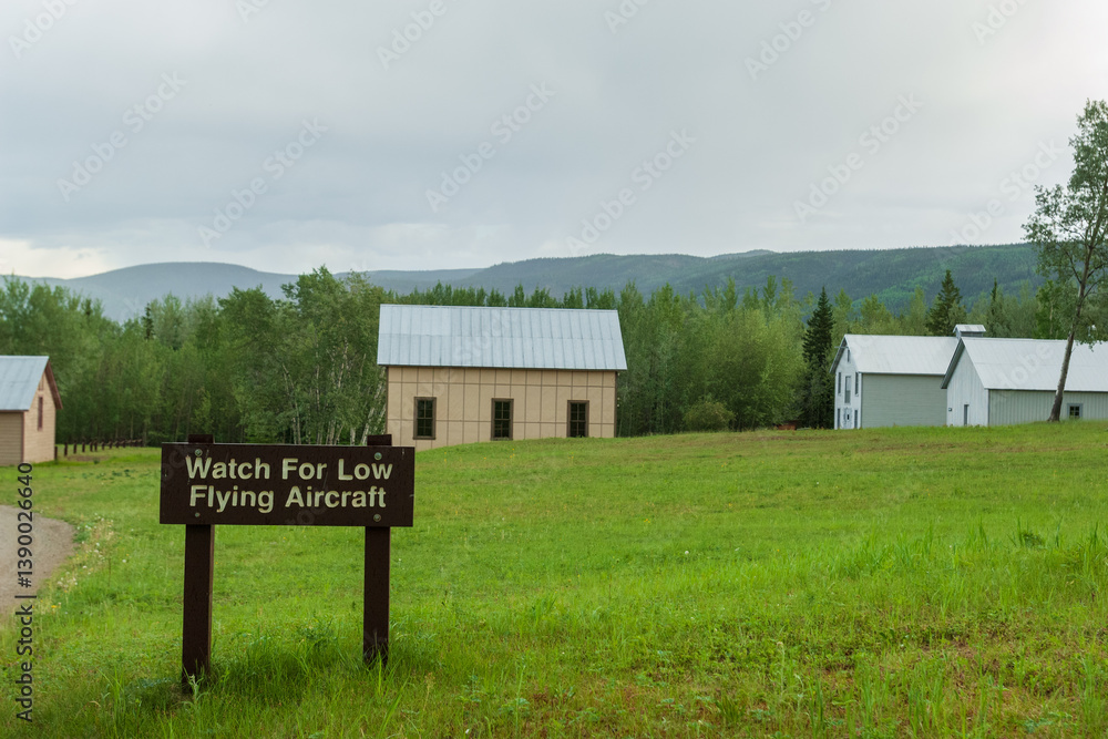 Obraz premium Warning sign of low flying aircrafts near local airport in the Eagle, remote Alaskan village on Yukon river, USA