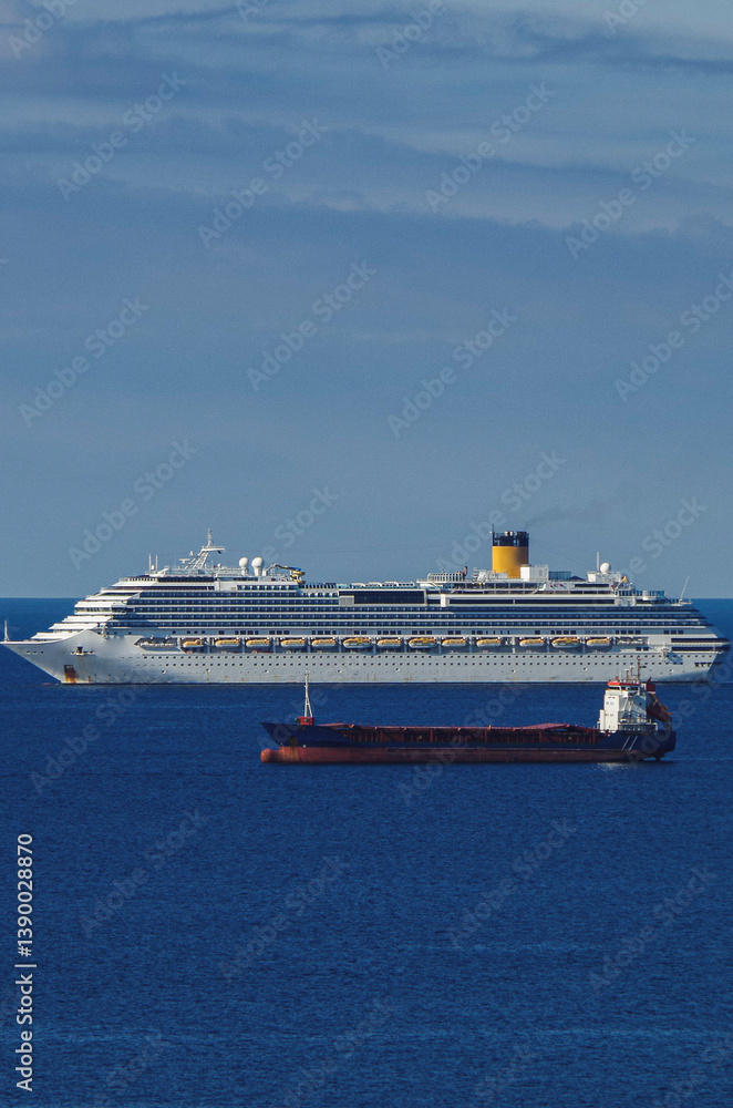 Mega family cruiseship cruise ship liner Favolosa and bunker ship anchored offshore of Civitavecchia Rome, Italy before reactived after Covid pandemic with other vessels in port and coastline