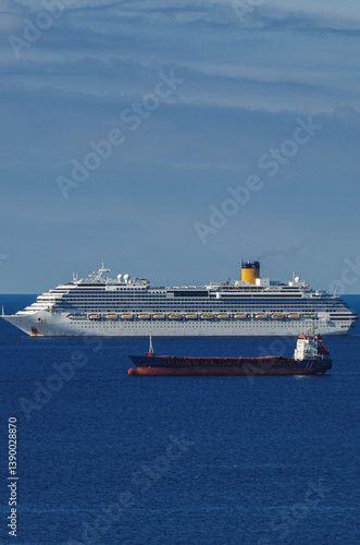 Obraz na płótnie Mega family cruiseship cruise ship liner Favolosa and bunker ship anchored offshore of Civitavecchia Rome, Italy before reactived after Covid pandemic with other vessels in port and coastline w salonie